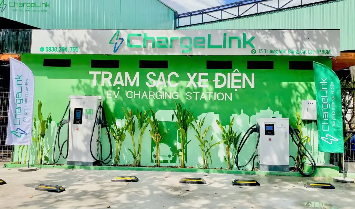 ChargeLink charging station in Cat Lai, Ho Chi Minh City: two DC fast chargers in front of a green wall reading “Trạm sạc xe điện” (EV charging station)