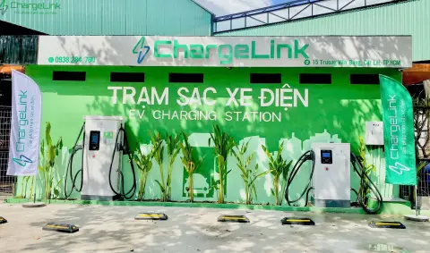 ChargeLink charging station in Cat Lai, Ho Chi Minh City: two DC fast chargers in front of a green wall reading “Trạm sạc xe điện” (EV charging station)